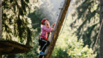 Kind auf einer Leiter im Waldseilgarten Höllschlucht, Pfronten im Allgäu